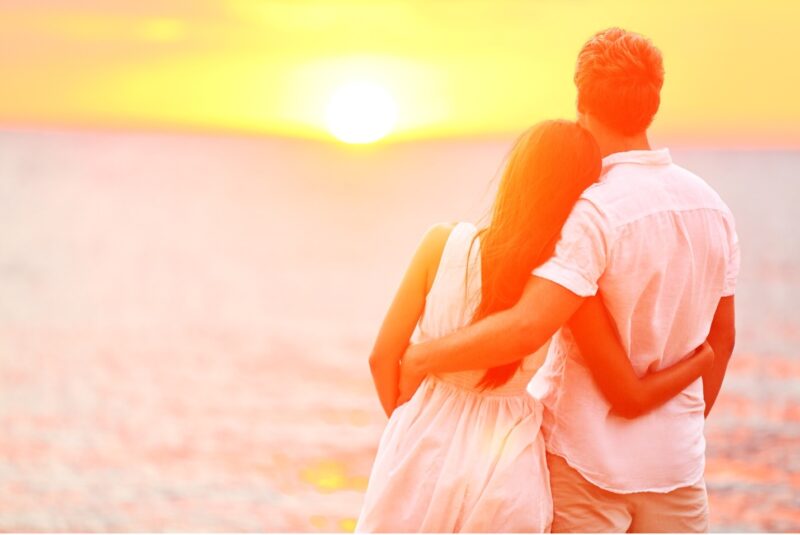 Newlywed couple on honeymoon, romantic beach sunset