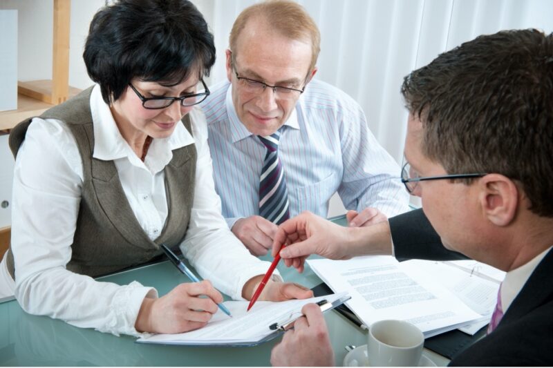 Senior couple reviewing estate planning documents with a financial advisor.